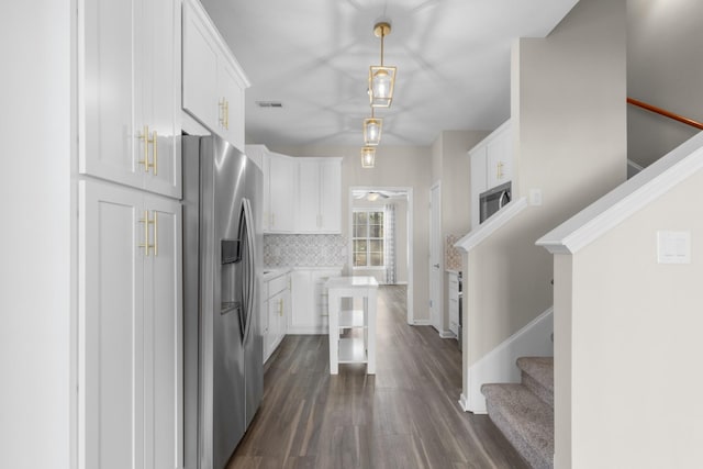 kitchen featuring backsplash, built in microwave, white cabinets, and stainless steel refrigerator with ice dispenser