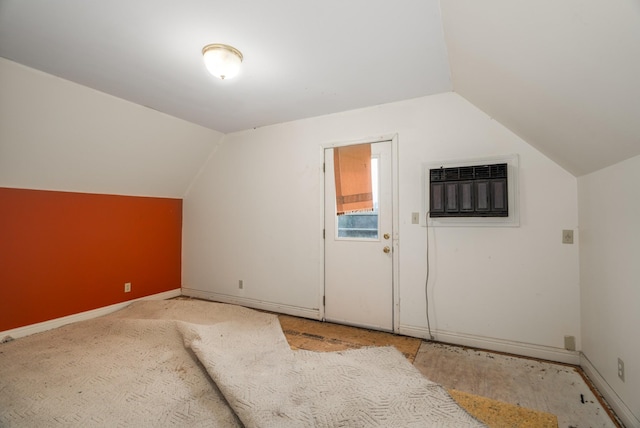 additional living space with lofted ceiling and a wall mounted AC