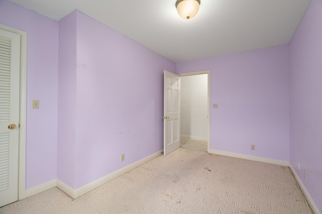 unfurnished bedroom with light carpet and a closet