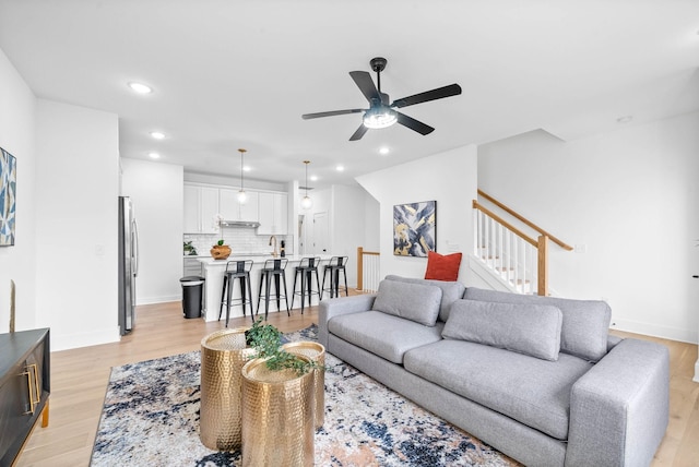 living room with light wood-type flooring and ceiling fan