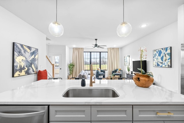 kitchen with gray cabinetry, light stone countertops, pendant lighting, and stainless steel dishwasher