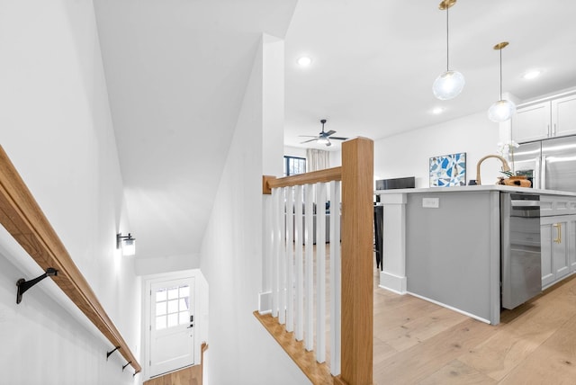 stairs featuring hardwood / wood-style floors, ceiling fan, and sink