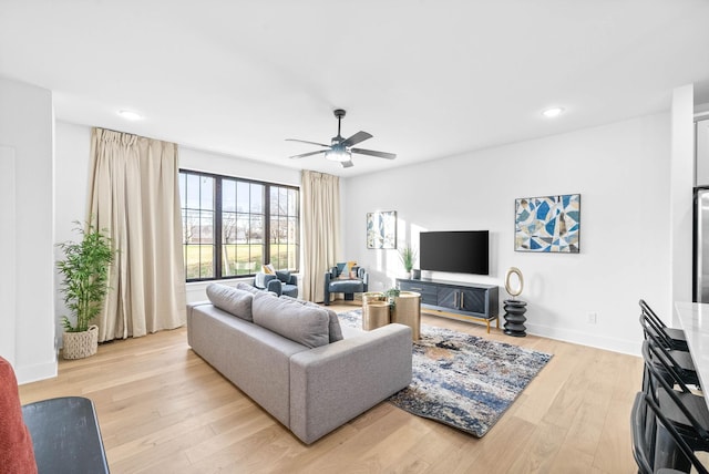 living room with ceiling fan and light hardwood / wood-style flooring