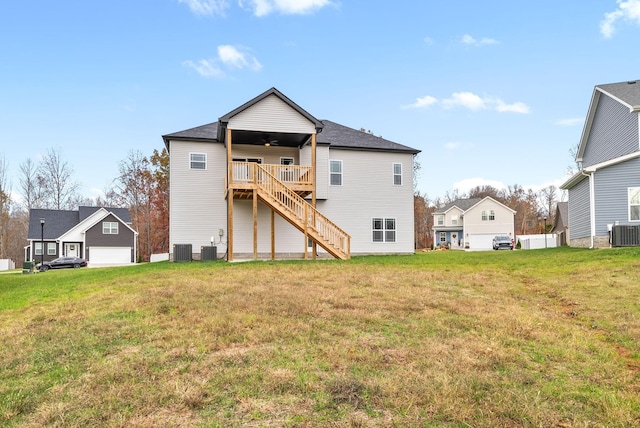 rear view of house featuring a lawn, ceiling fan, a wooden deck, and central AC