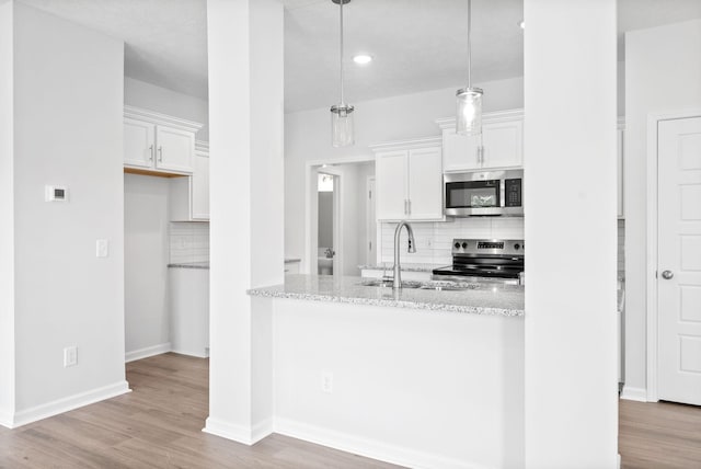 kitchen featuring white cabinetry, sink, pendant lighting, and appliances with stainless steel finishes