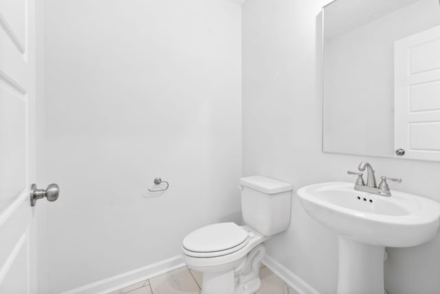 bathroom featuring tile patterned flooring, toilet, and sink