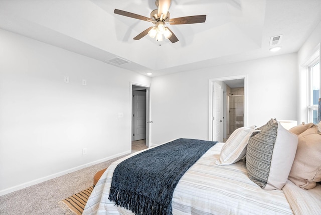 bedroom featuring connected bathroom, carpet floors, a raised ceiling, and ceiling fan