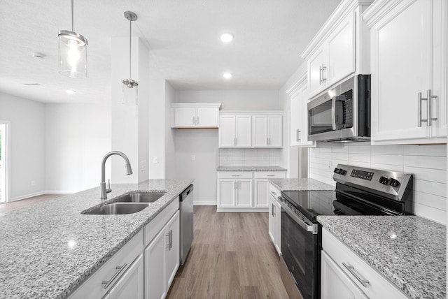 kitchen with white cabinets, stainless steel appliances, tasteful backsplash, and sink