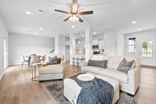 living room featuring light hardwood / wood-style floors and ceiling fan