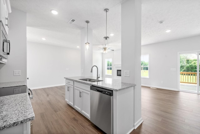 kitchen with light stone countertops, white cabinetry, sink, and stainless steel dishwasher