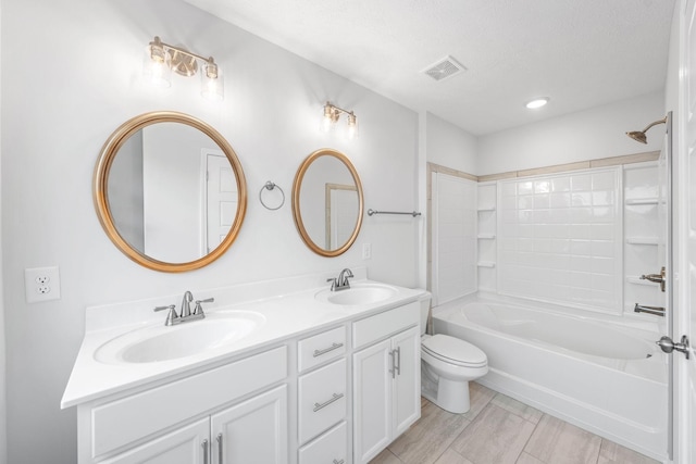 full bathroom featuring a textured ceiling, vanity,  shower combination, and toilet