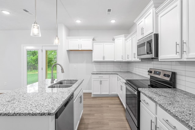 kitchen featuring white cabinets, decorative light fixtures, sink, and appliances with stainless steel finishes