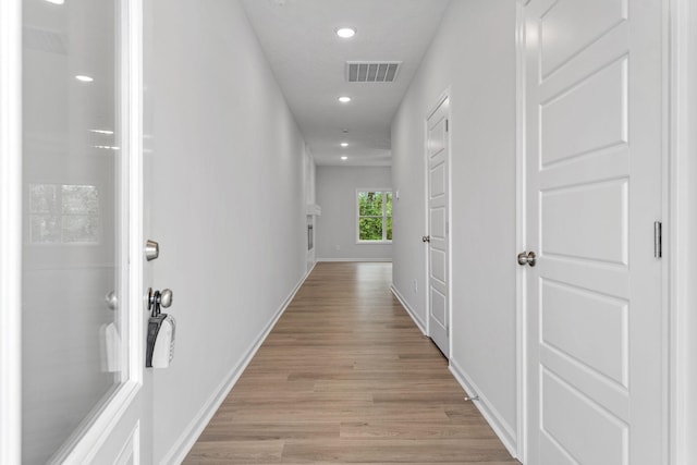 hallway with light hardwood / wood-style floors