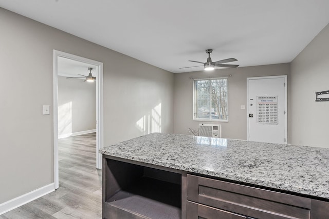 kitchen with ceiling fan, light hardwood / wood-style flooring, and light stone counters