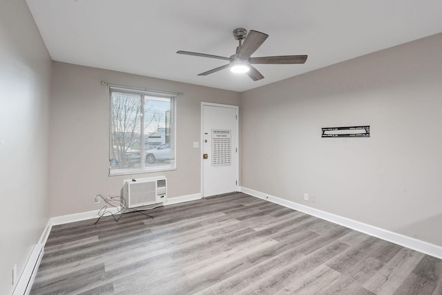 empty room featuring a wall unit AC, ceiling fan, and light hardwood / wood-style floors