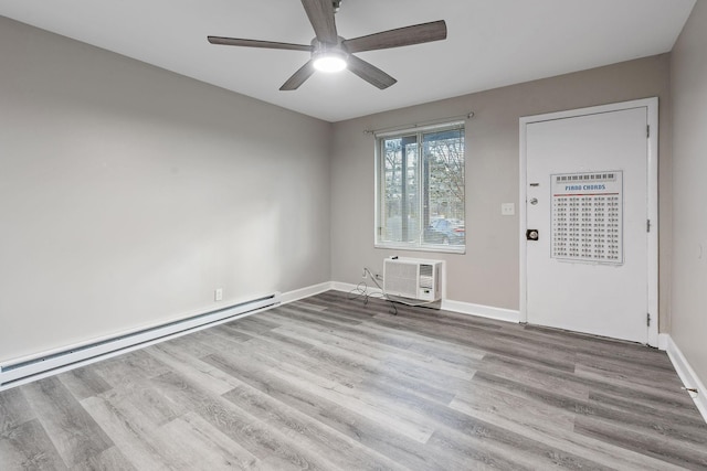 empty room with a baseboard radiator, a wall unit AC, ceiling fan, and light hardwood / wood-style flooring