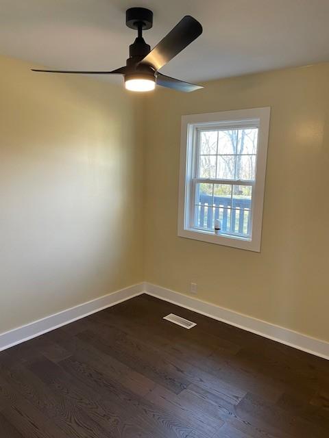 unfurnished room featuring dark hardwood / wood-style floors and ceiling fan