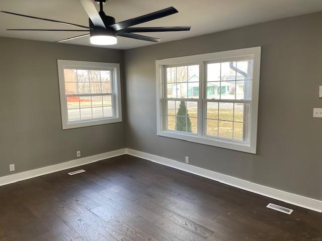 empty room featuring ceiling fan and dark hardwood / wood-style floors