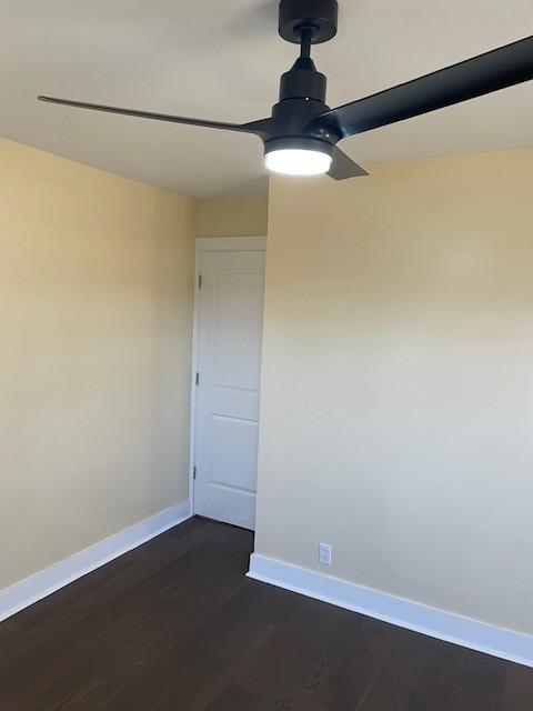 empty room featuring ceiling fan and dark hardwood / wood-style floors