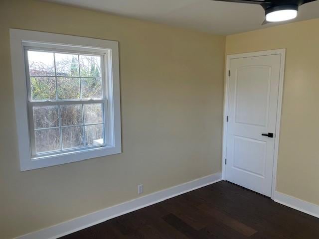 empty room with dark wood-type flooring and ceiling fan