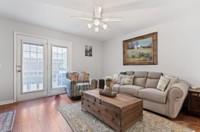 living room featuring ceiling fan and dark hardwood / wood-style floors