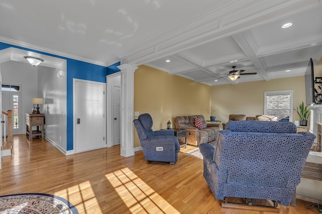 living room featuring coffered ceiling, light hardwood / wood-style flooring, ceiling fan, ornamental molding, and beam ceiling