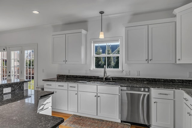 kitchen with stainless steel dishwasher, dark stone countertops, white cabinetry, and sink