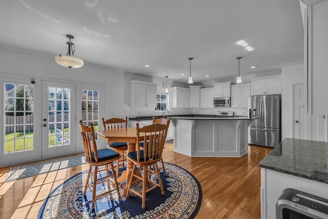 dining room featuring light hardwood / wood-style floors, sink, crown molding, and french doors