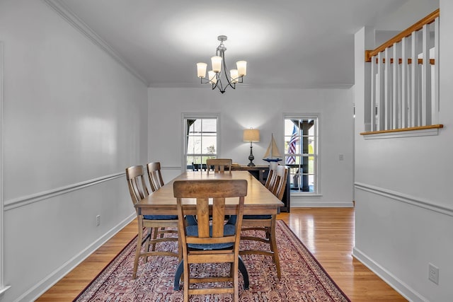 dining area featuring a chandelier, light hardwood / wood-style floors, and crown molding