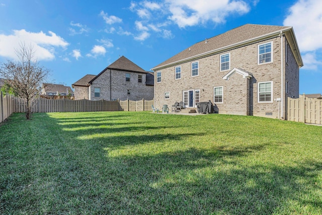 rear view of property featuring a lawn and a patio area