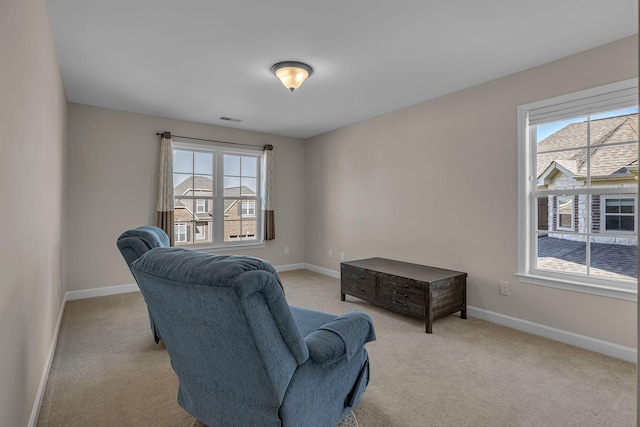 living area featuring light carpet