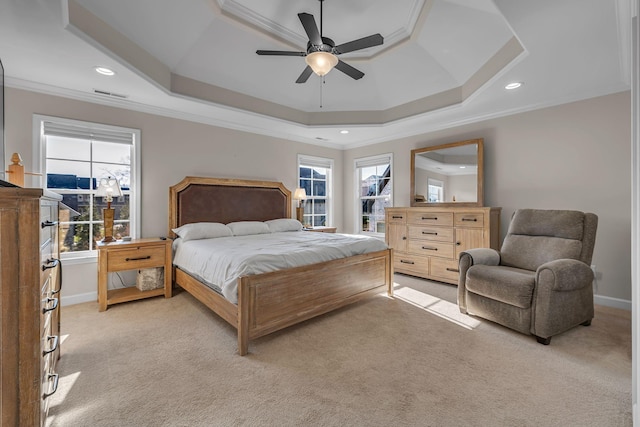 carpeted bedroom with ceiling fan, multiple windows, crown molding, and a tray ceiling