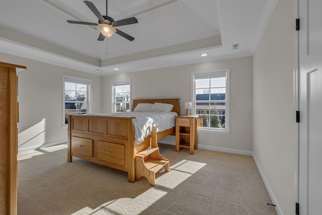 carpeted bedroom with a tray ceiling, ceiling fan, and crown molding