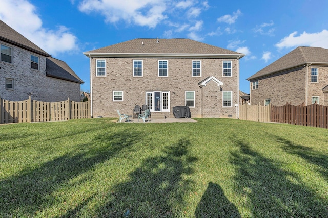 back of house featuring a lawn and a patio