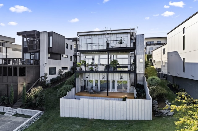 back of property with central AC unit and a balcony