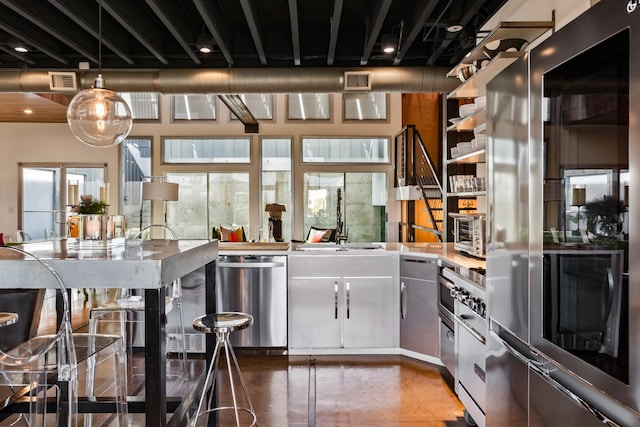 kitchen with dishwasher, black refrigerator, a healthy amount of sunlight, and sink