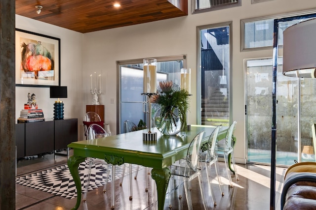 tiled dining space with a wealth of natural light and wood ceiling