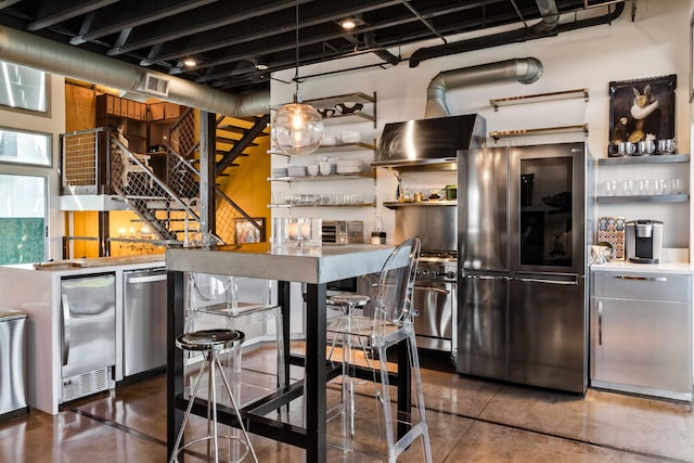 kitchen with fridge, stainless steel fridge, wall chimney exhaust hood, and decorative light fixtures