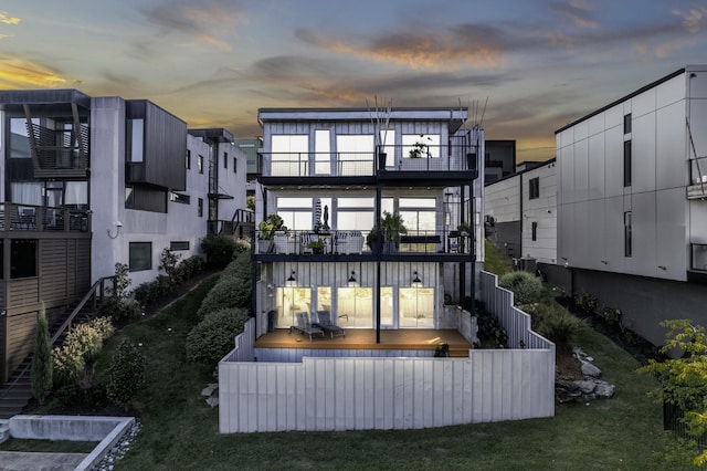 back house at dusk with a balcony