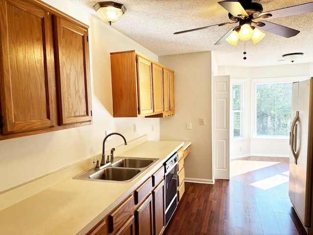 kitchen featuring ceiling fan, white fridge with ice dispenser, sink, dark wood-type flooring, and a textured ceiling