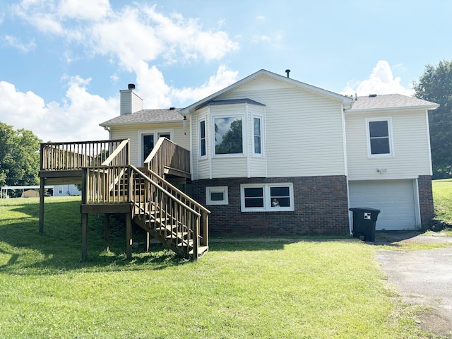 back of property with a lawn, a deck, and a garage