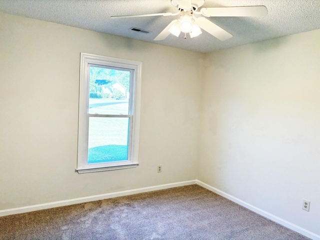 empty room with carpet, ceiling fan, and a textured ceiling