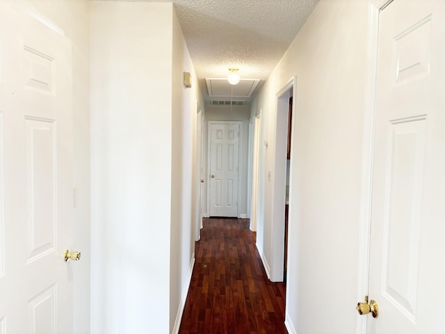 hall with dark hardwood / wood-style flooring and a textured ceiling