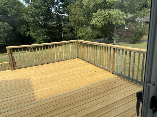 wooden deck featuring a lawn