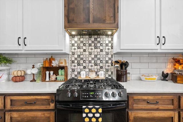 kitchen with backsplash, white cabinets, and black gas range oven