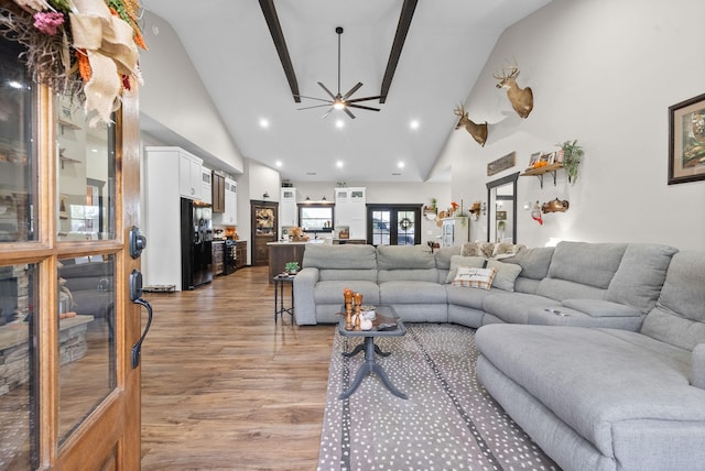 living room featuring ceiling fan, french doors, high vaulted ceiling, and light hardwood / wood-style floors