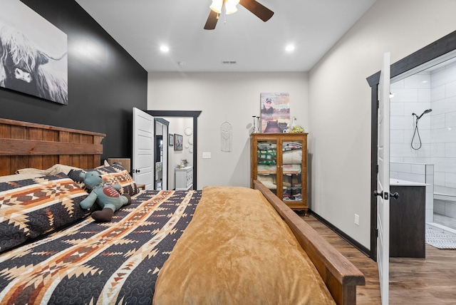 bedroom with ensuite bath, ceiling fan, and dark hardwood / wood-style flooring