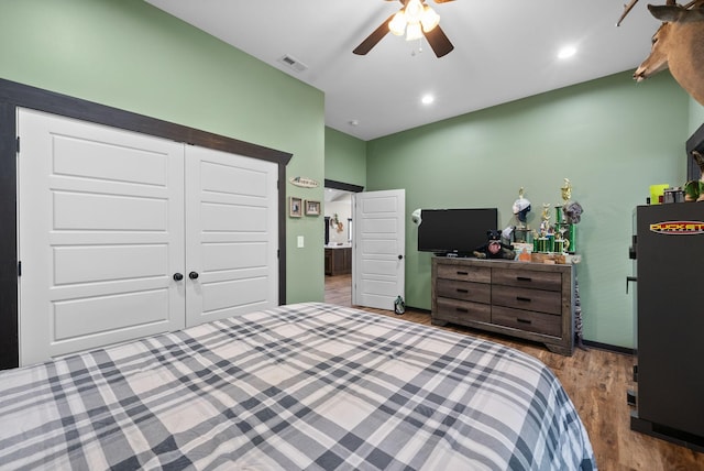 bedroom featuring ceiling fan, a closet, and hardwood / wood-style flooring