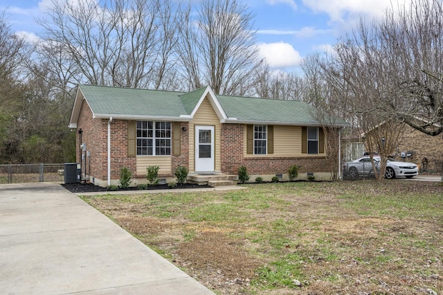 ranch-style house featuring cooling unit and a front lawn