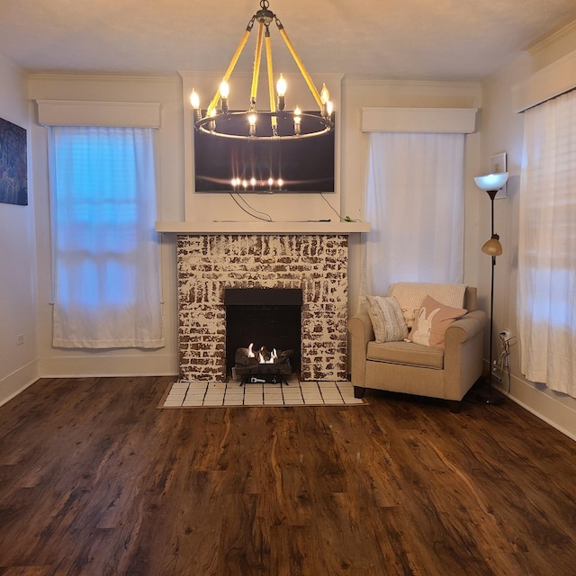 unfurnished room featuring a fireplace, crown molding, dark wood-type flooring, and a notable chandelier